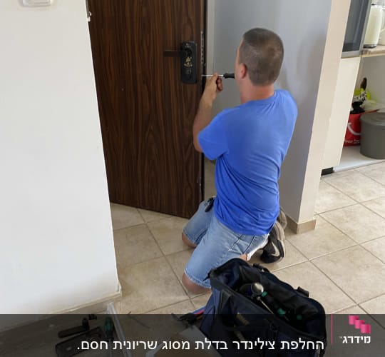 אדם מתקין מנעול בדלת עם כלים לידו